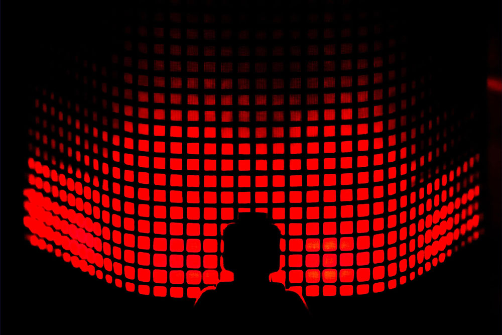 Image mise en avant - illustration d'un personnage légo dans l'ombre devant un panneau lumineux de carrés rouges
